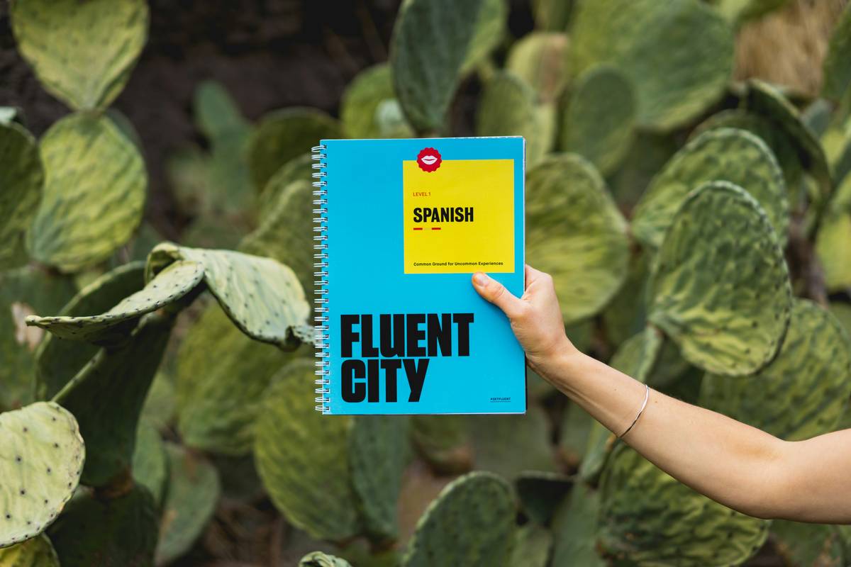 Woman using learning spanish program with duolingo on laptop while taking notes